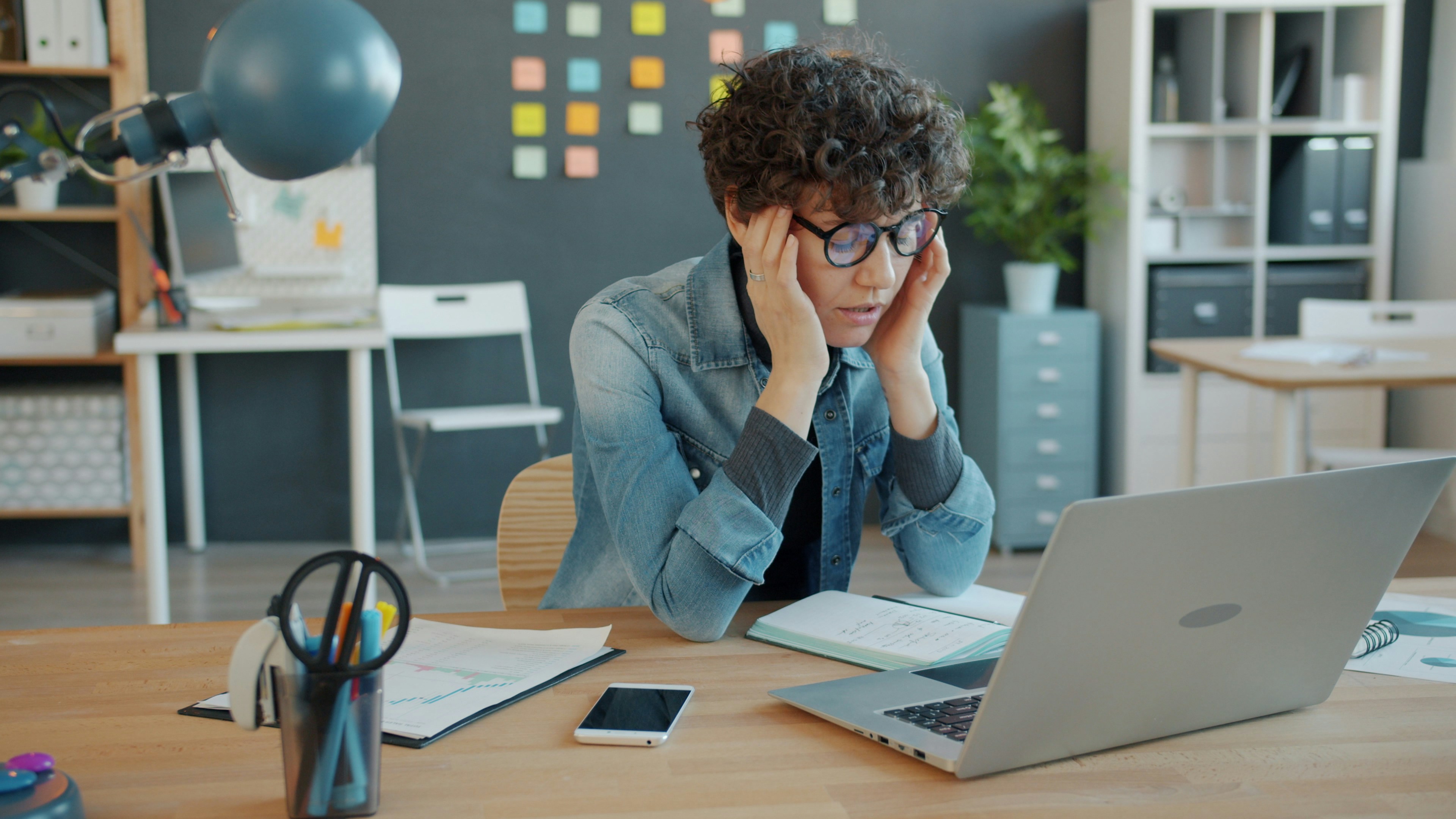 a-person-looking-stressed-at-a-laptop-in-an-office