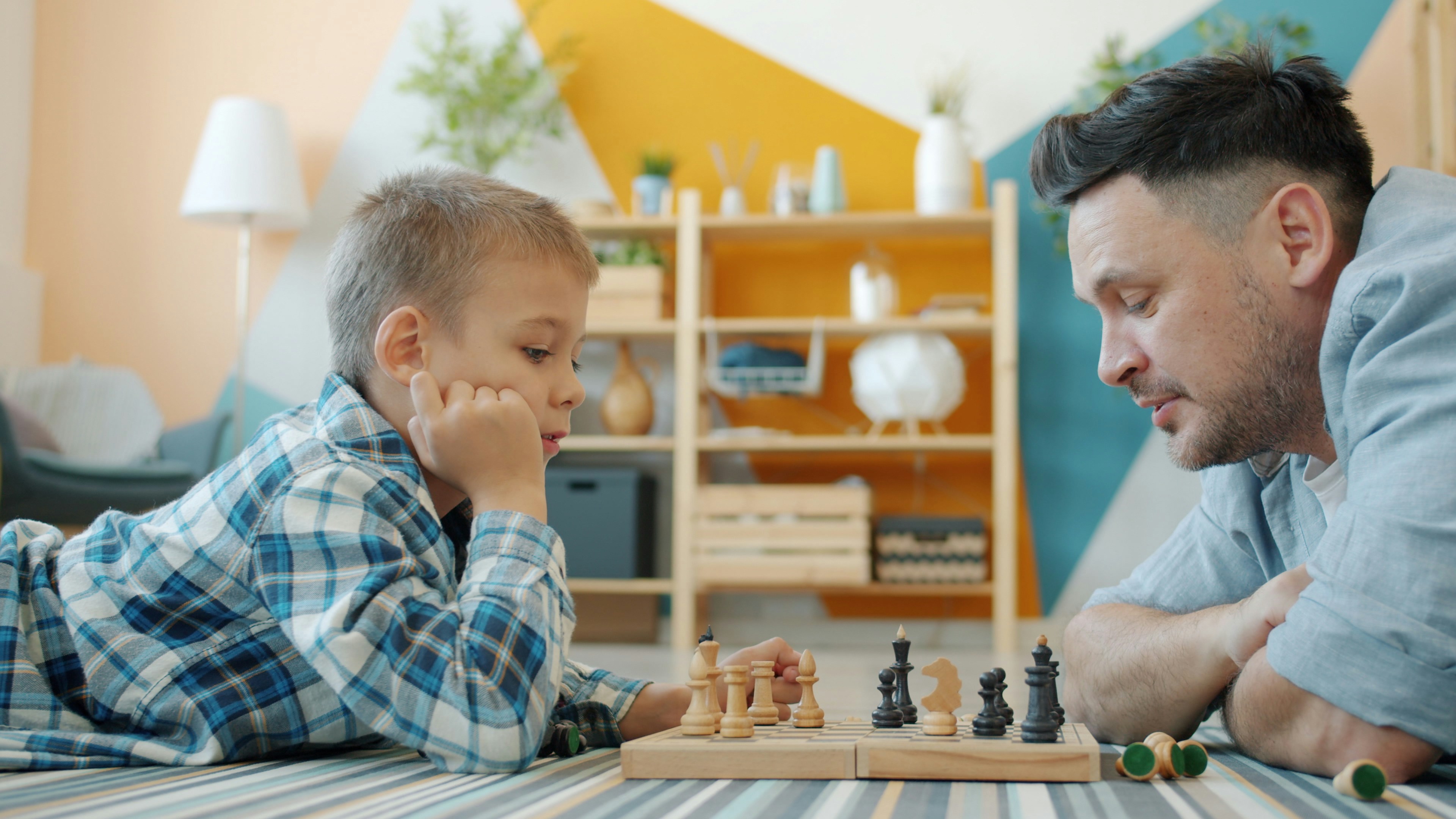father-and-son-playing-chess-on-the-floor