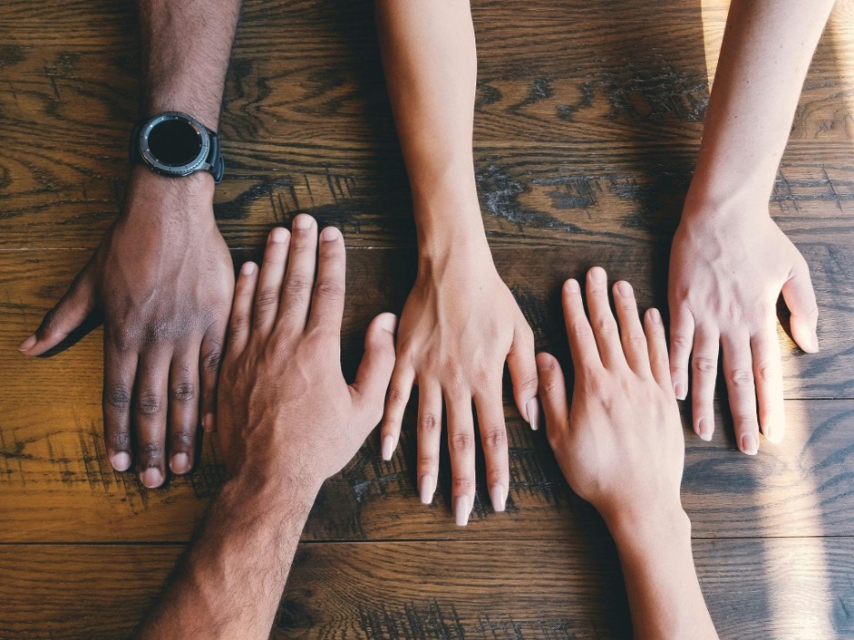 five-human-hands-on-brown-surface