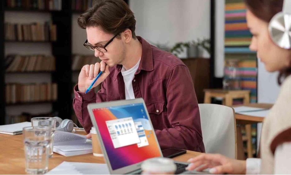 girl-with-headphones-using-laptop-along-her-classmates-group-study