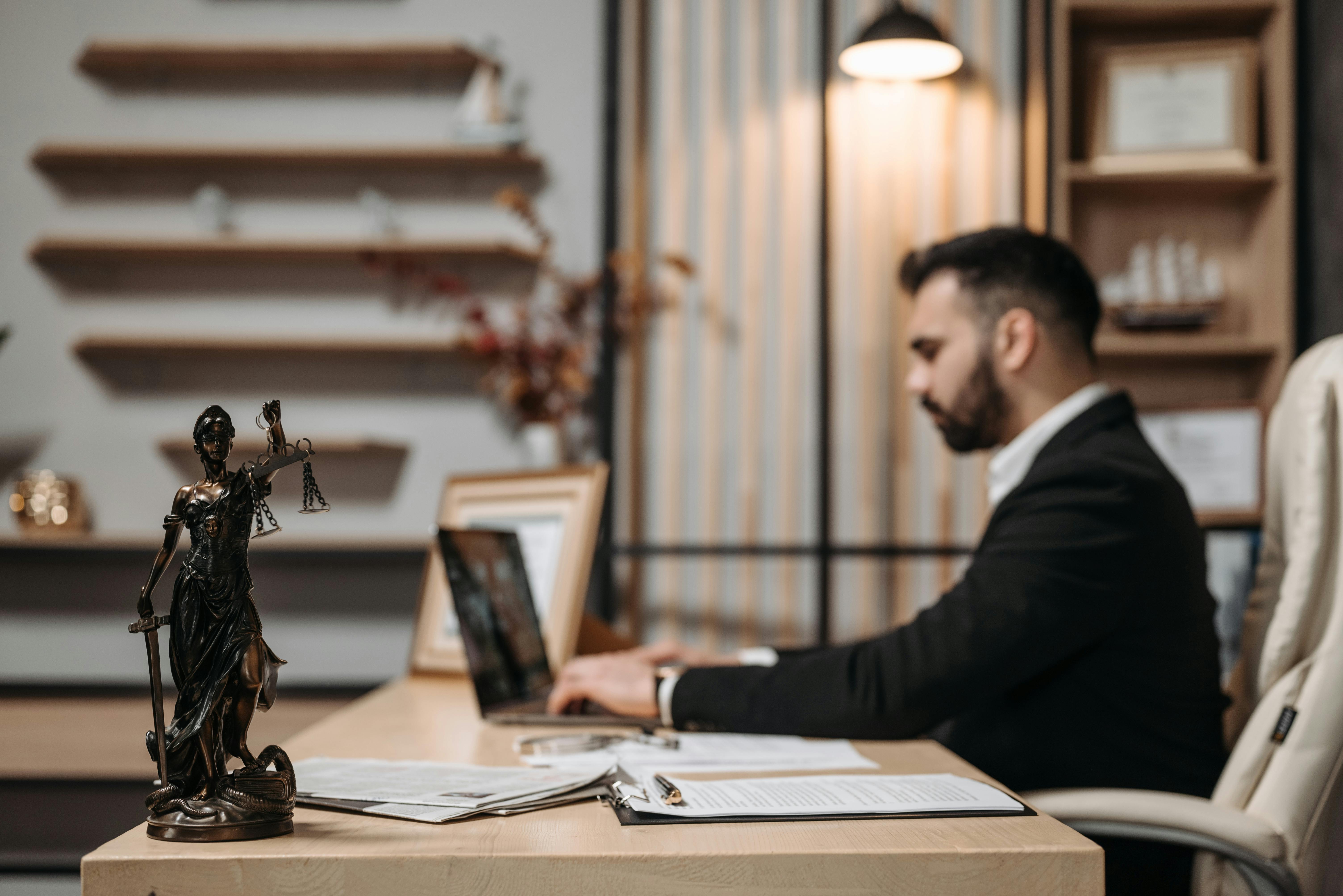 man-in-black-suit-jacket-using-a-laptop