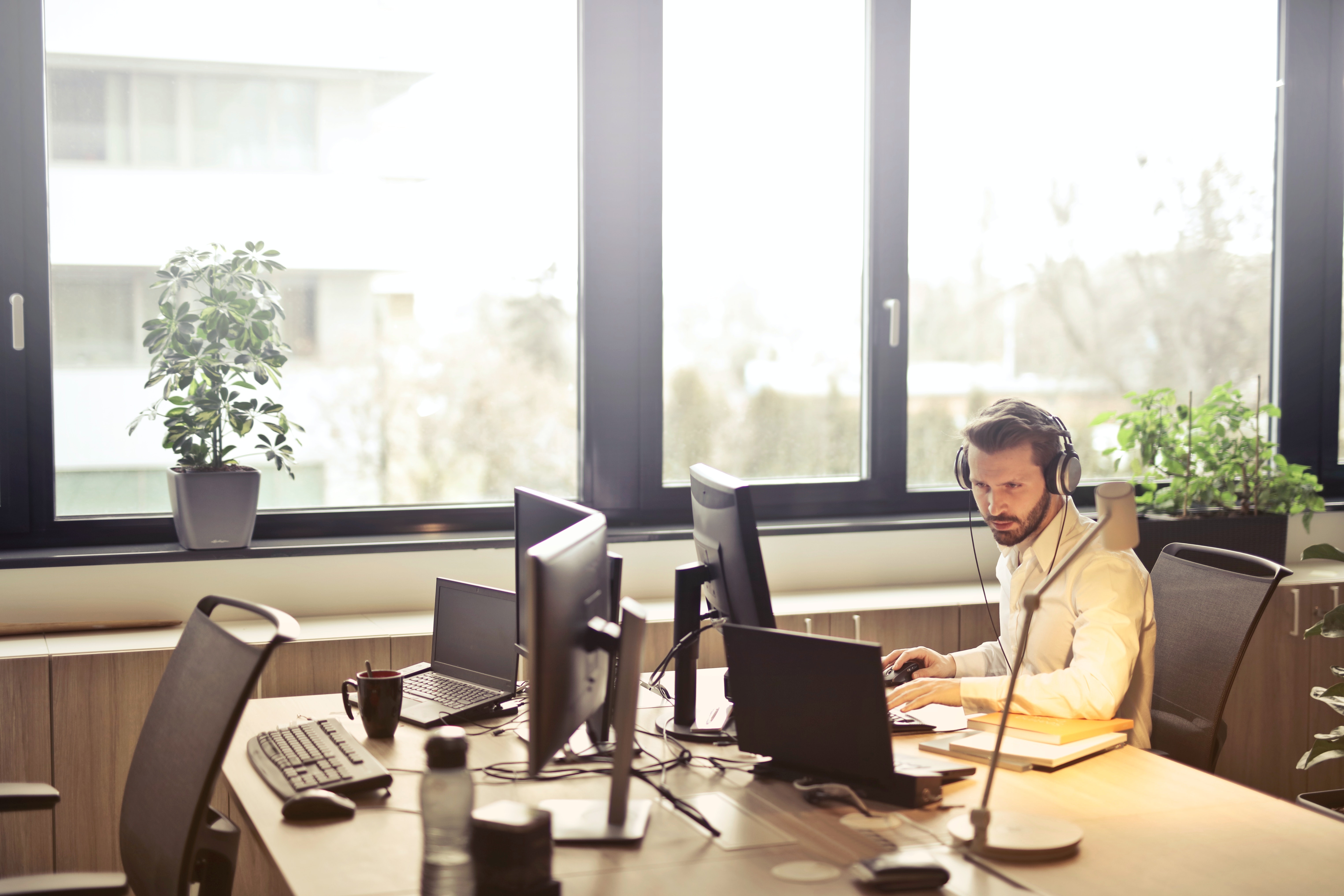 man with headphones facing computer