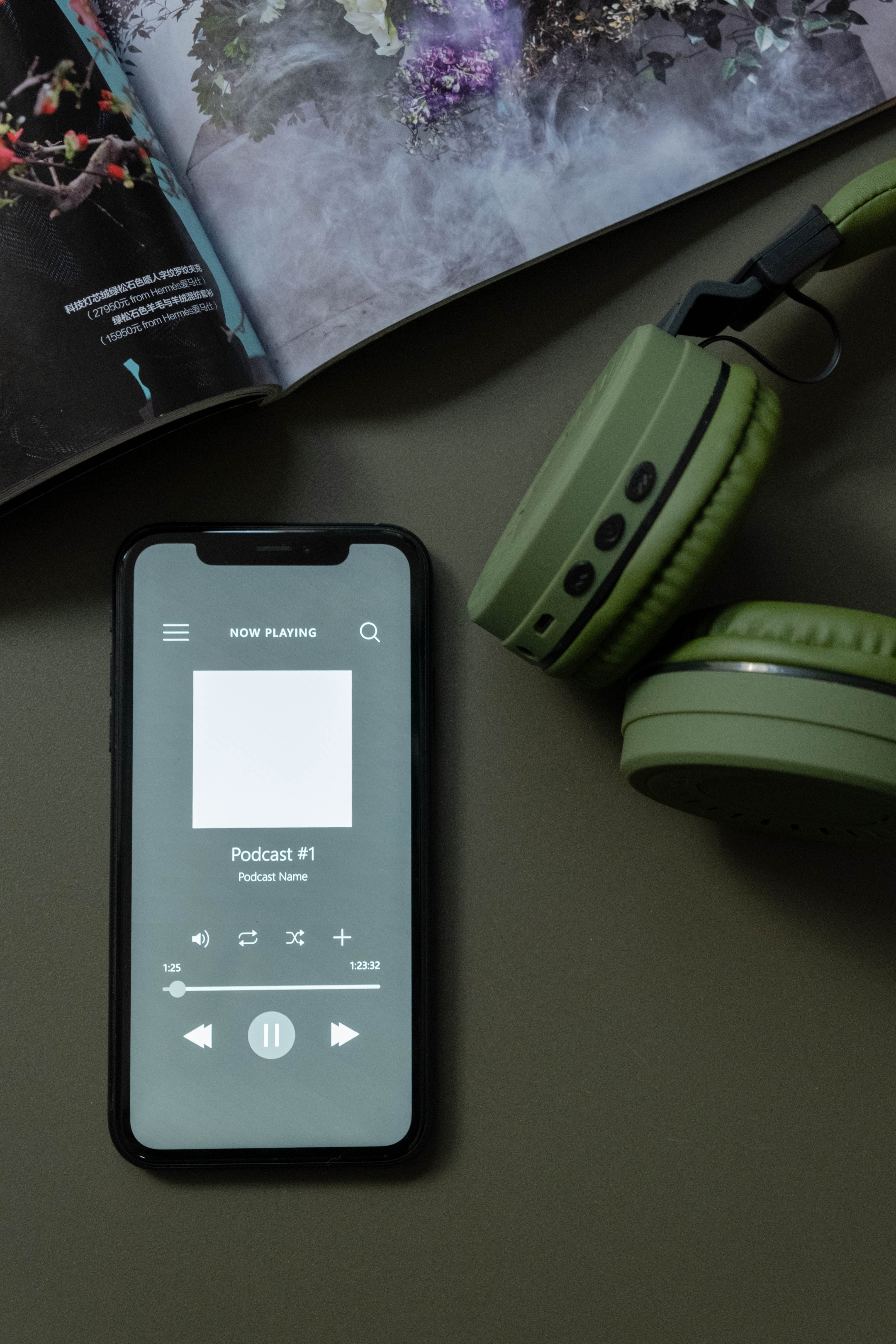 Image of phone and headphones on desk listening to podcast Starting_a_podcast_image_of_phone_headphones