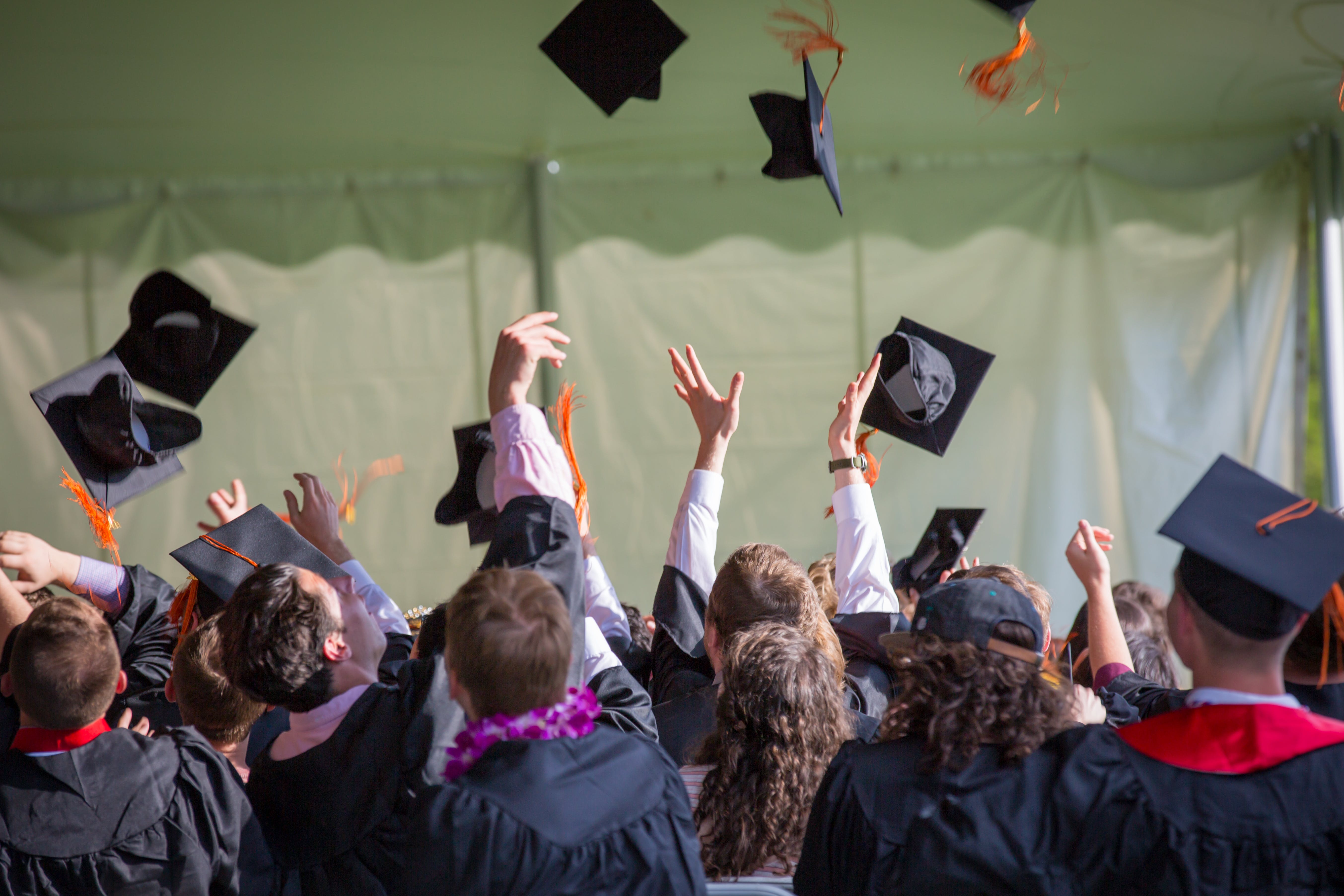 group of graduates throwing caps