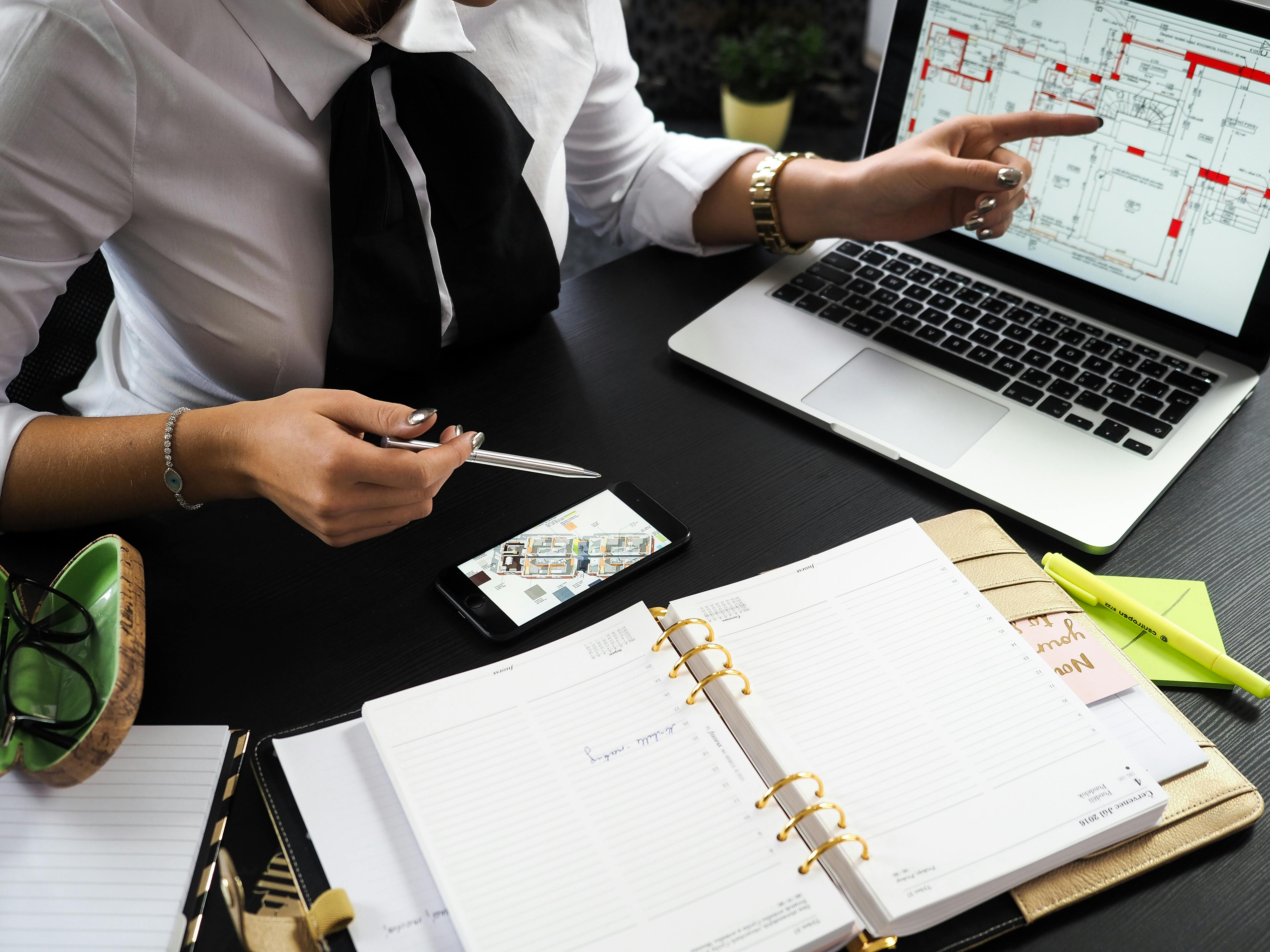 photo of female executive at desk pointing at laptop