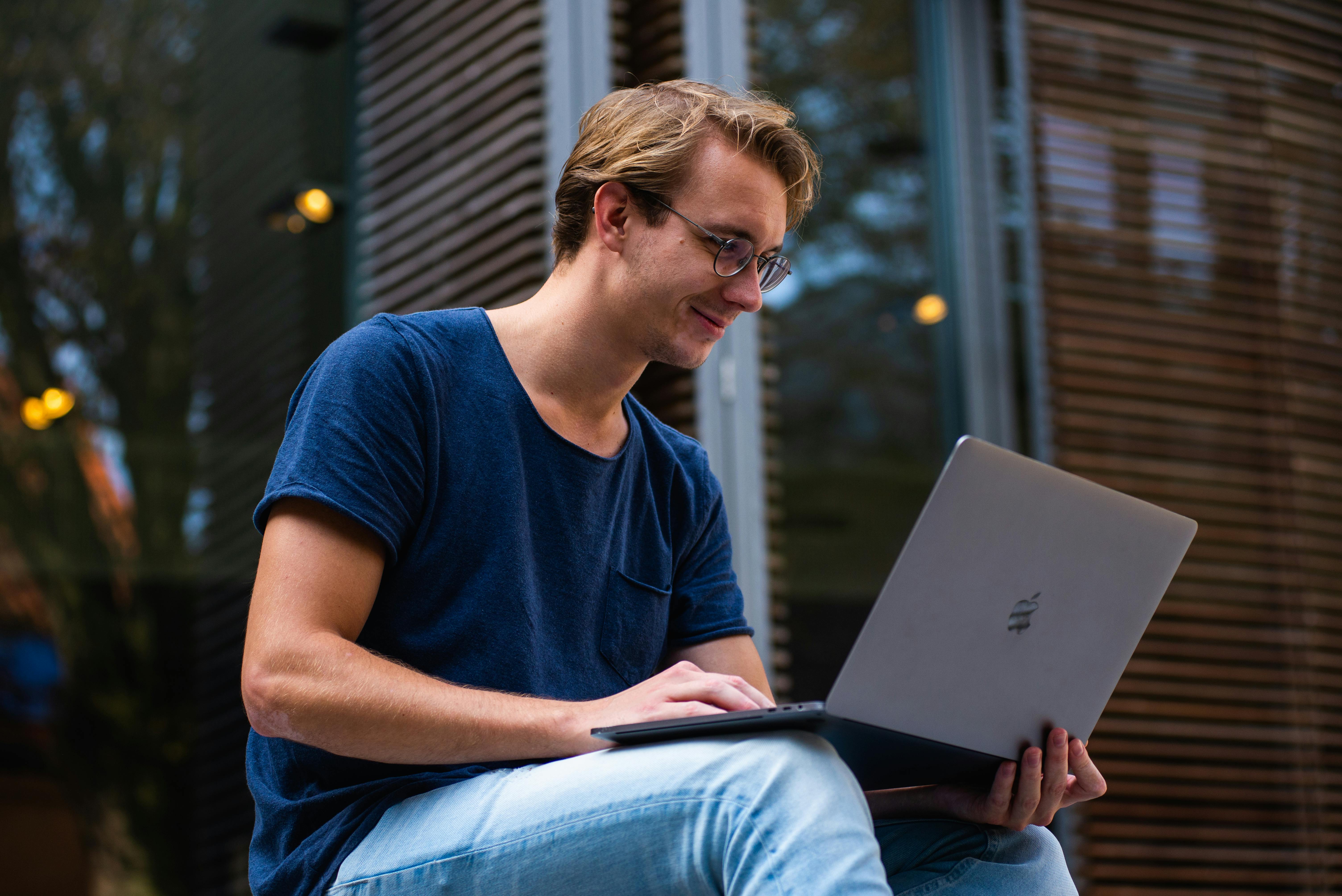 Man sitting and smiling with laptop