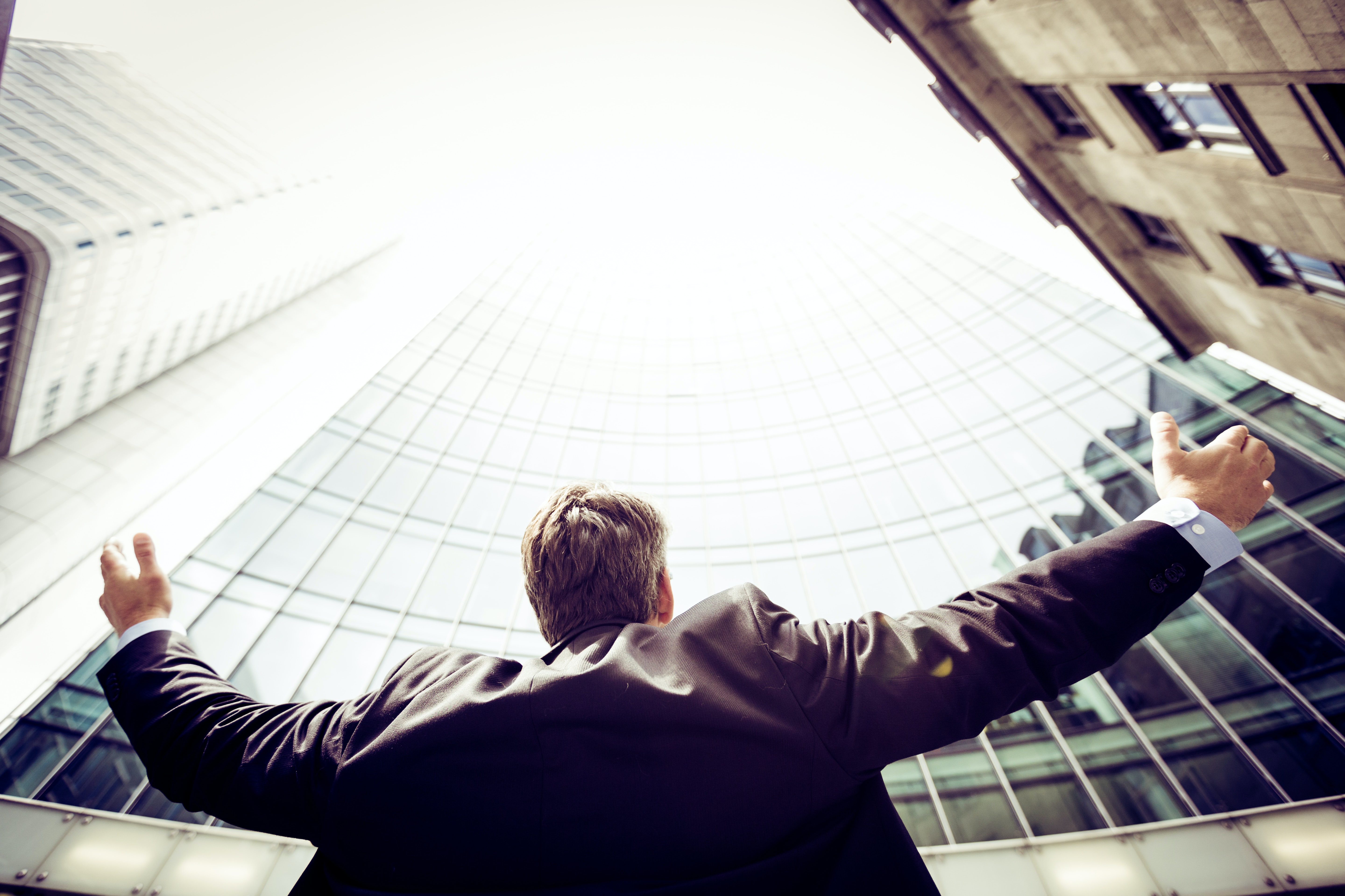 man looking up at buildings