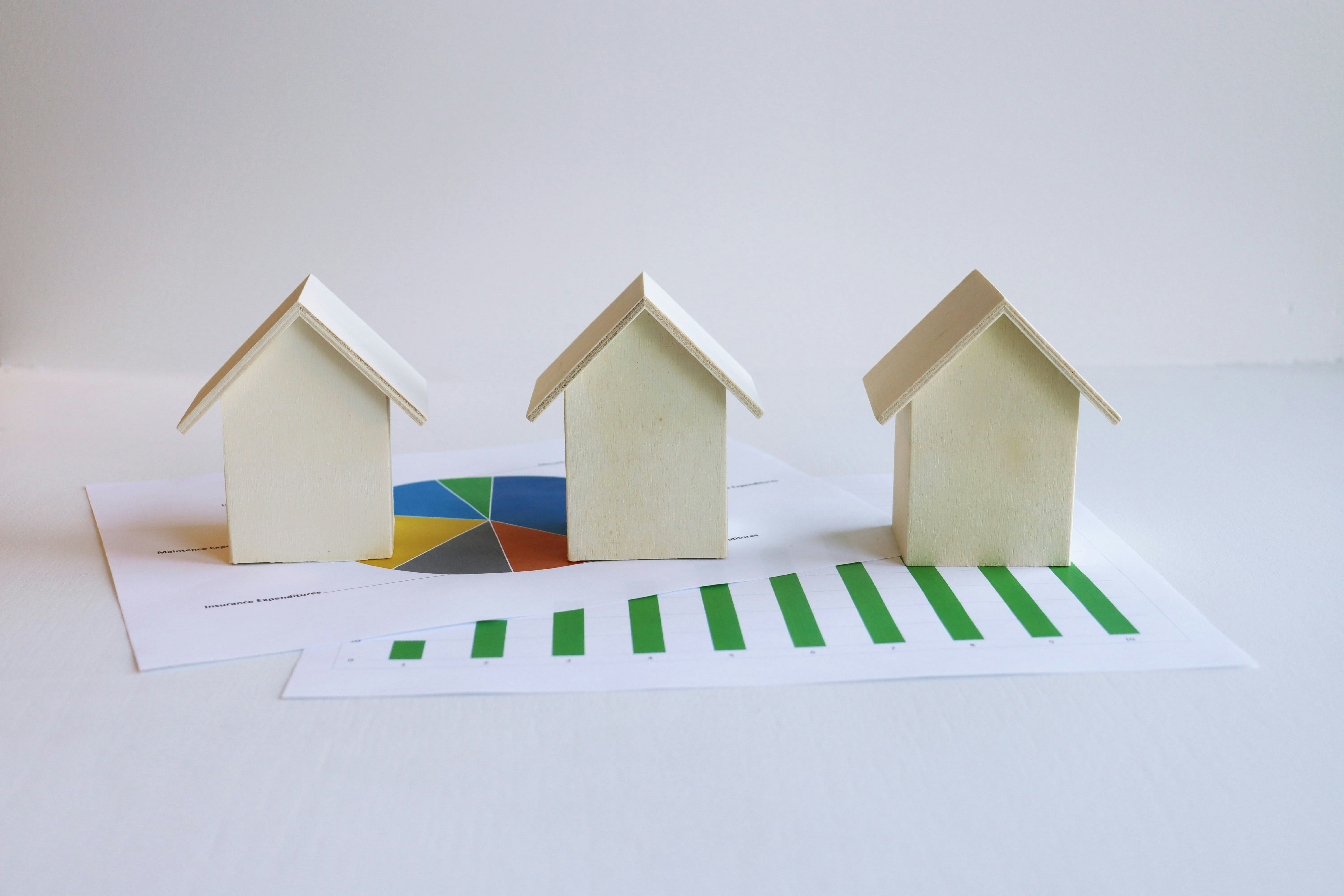 three-small-houses-sitting-on-top-of-a-piece-of-paper