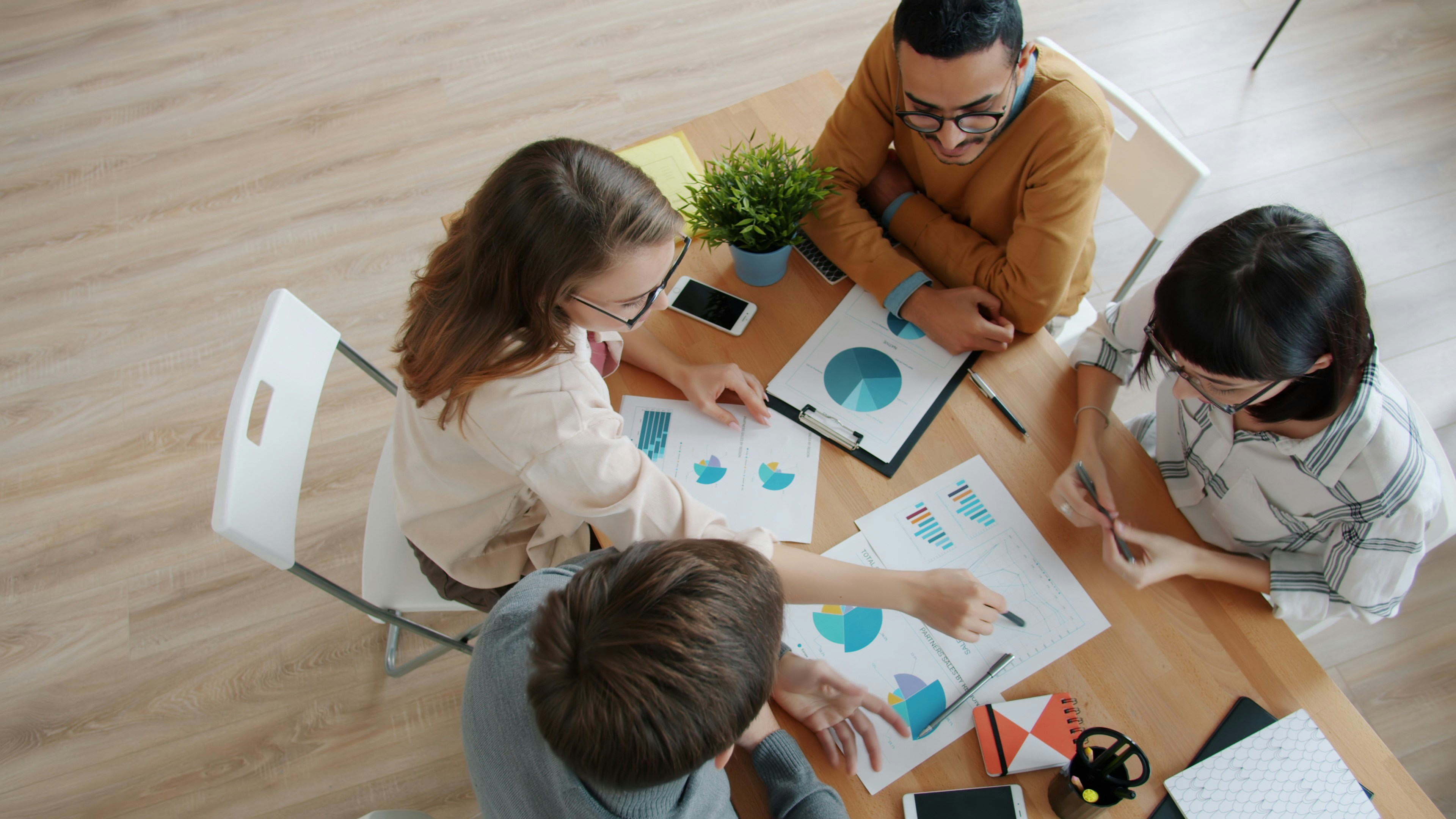 diverse-team-collaborating-around-a-table-with-charts