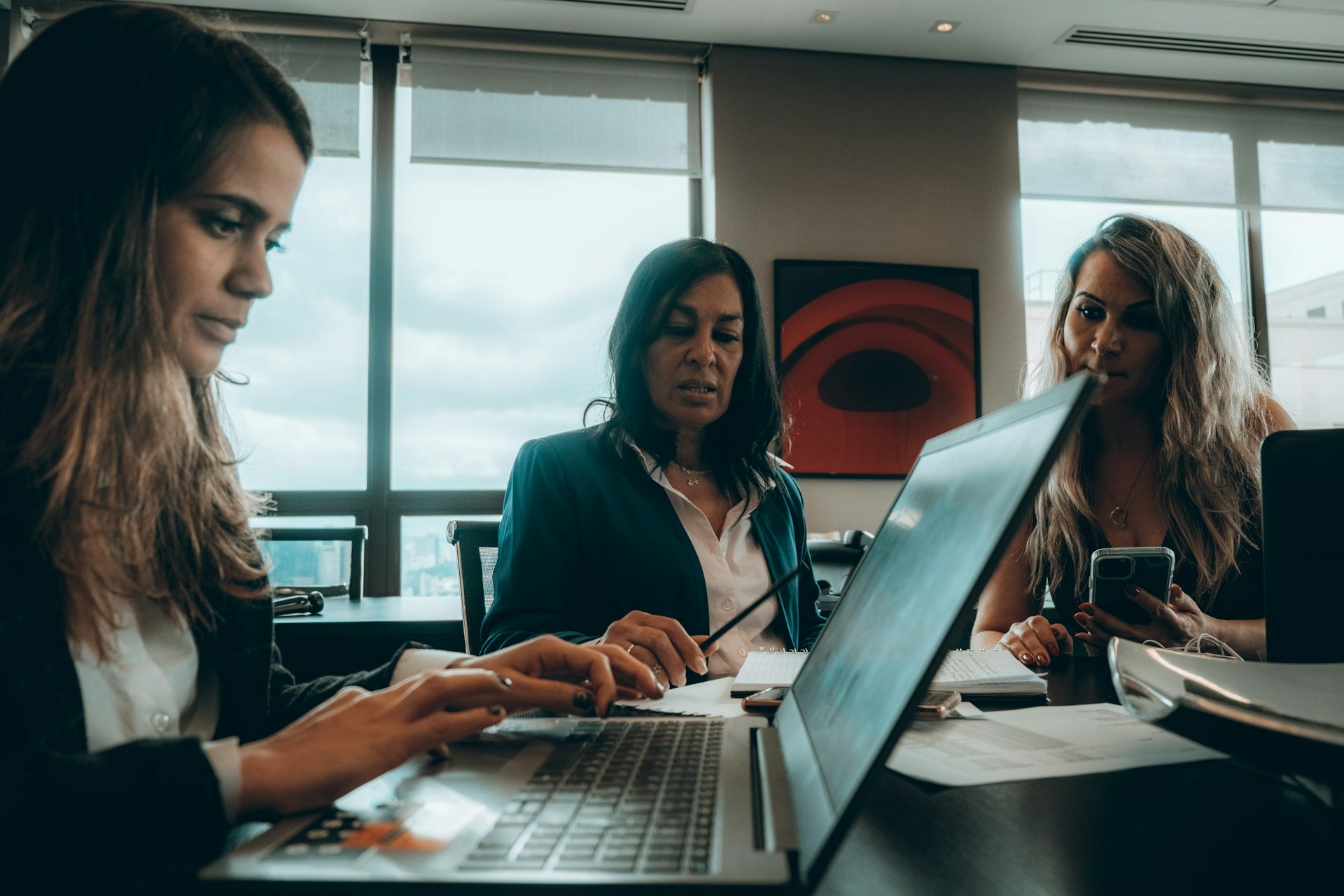 group of women sitting around a laptop computer group-of-women-sitting-around-a-laptop-computer