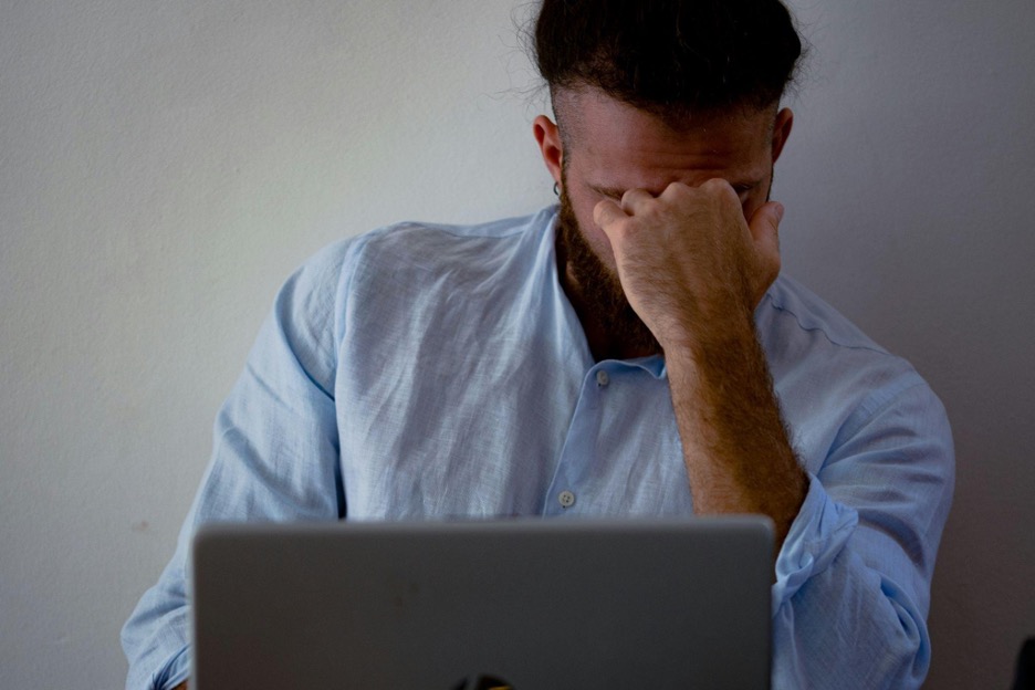 man-in-blue-dress-shirt-holding-silver-macbook