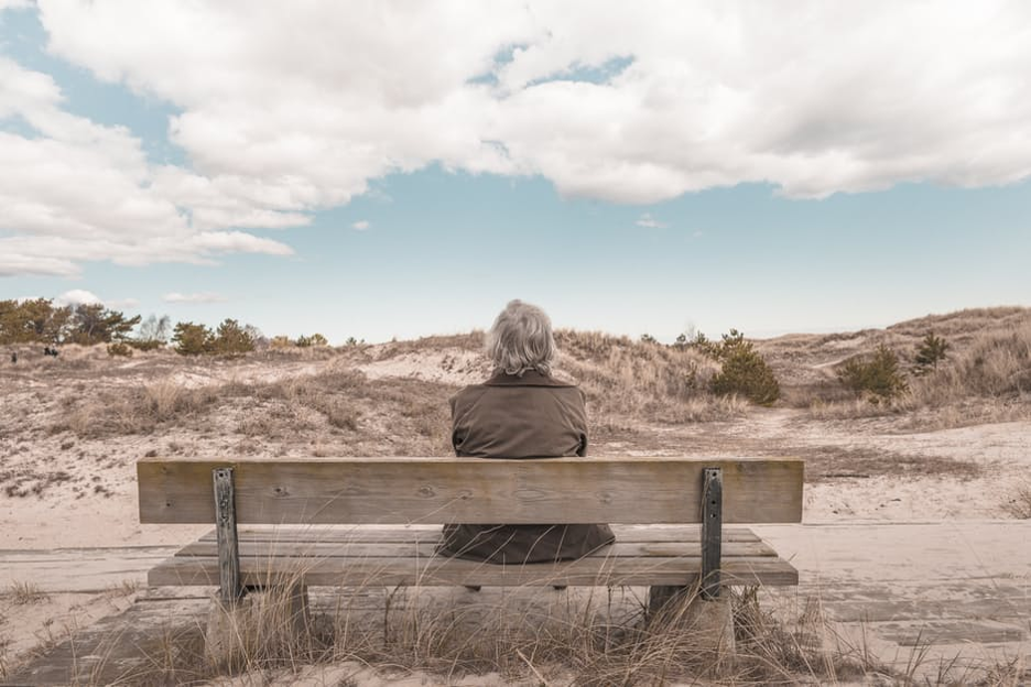 older-person-sitting-on-bench-facing-desert