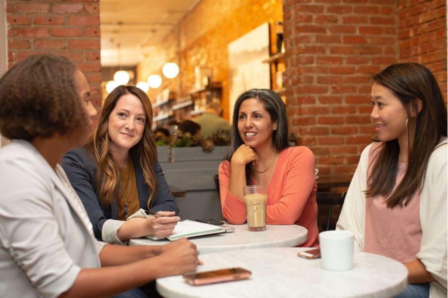 woman-in-black-jacket-sitting-beside-woman-in-white-blazer
