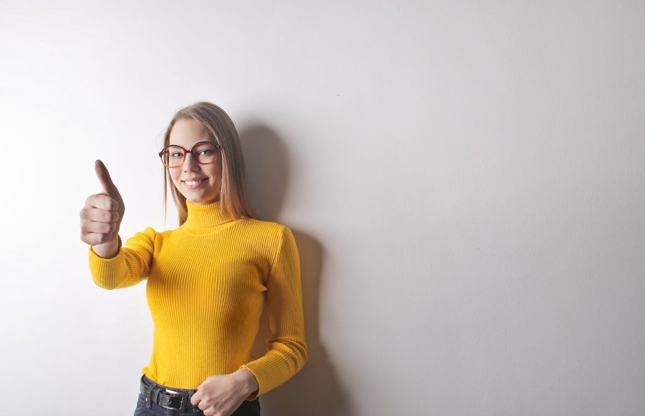 woman-in-yellow-turtleneck-sweater-blue-denim-jeans-and-glasses-giving-the-thumbs-up
