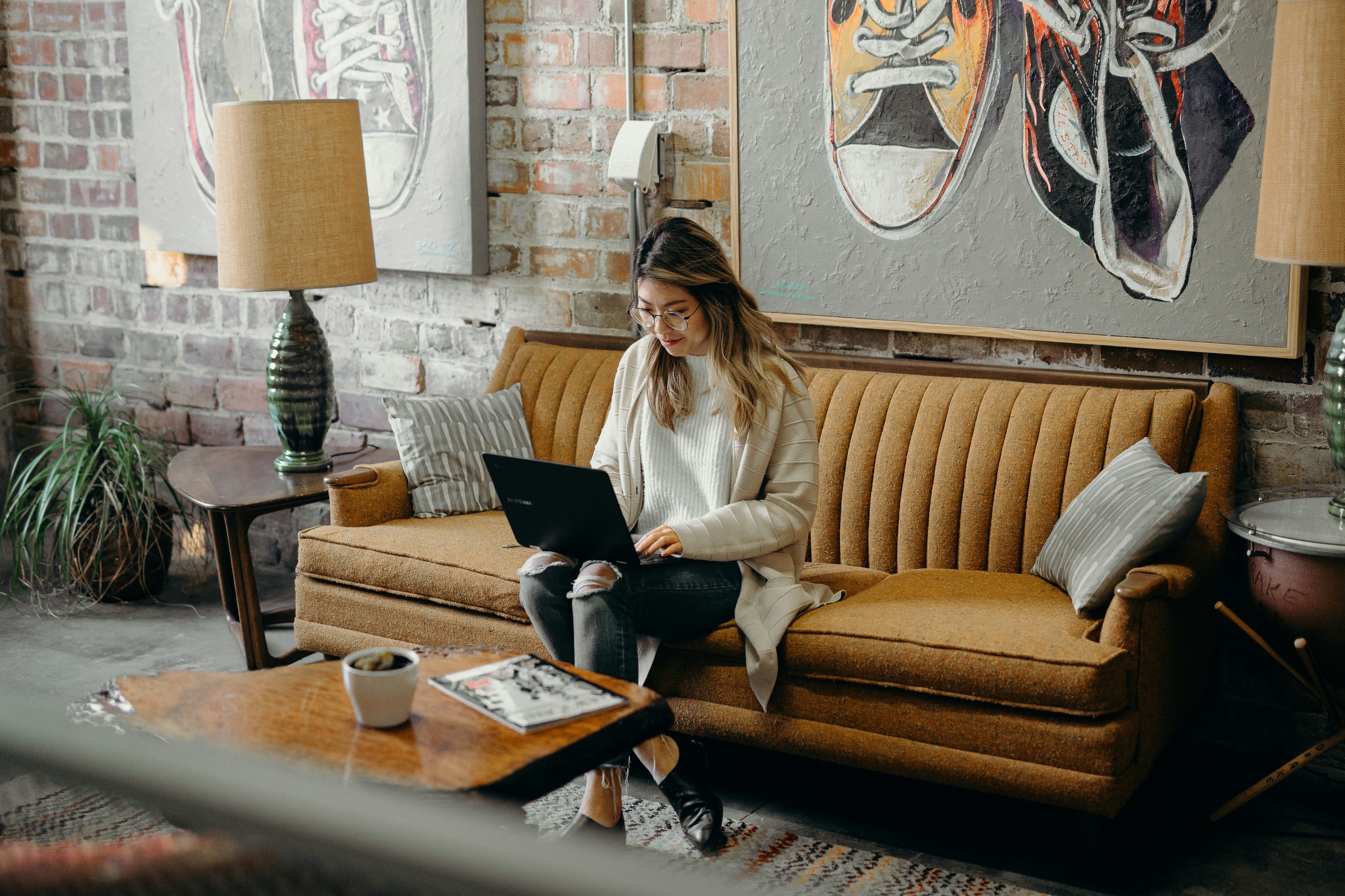 woman-using-laptop-while-sitting-on-chair